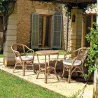 Fauteuil d'extérieur empilable dans un jardin en rotin naturel - Spora Viadurini